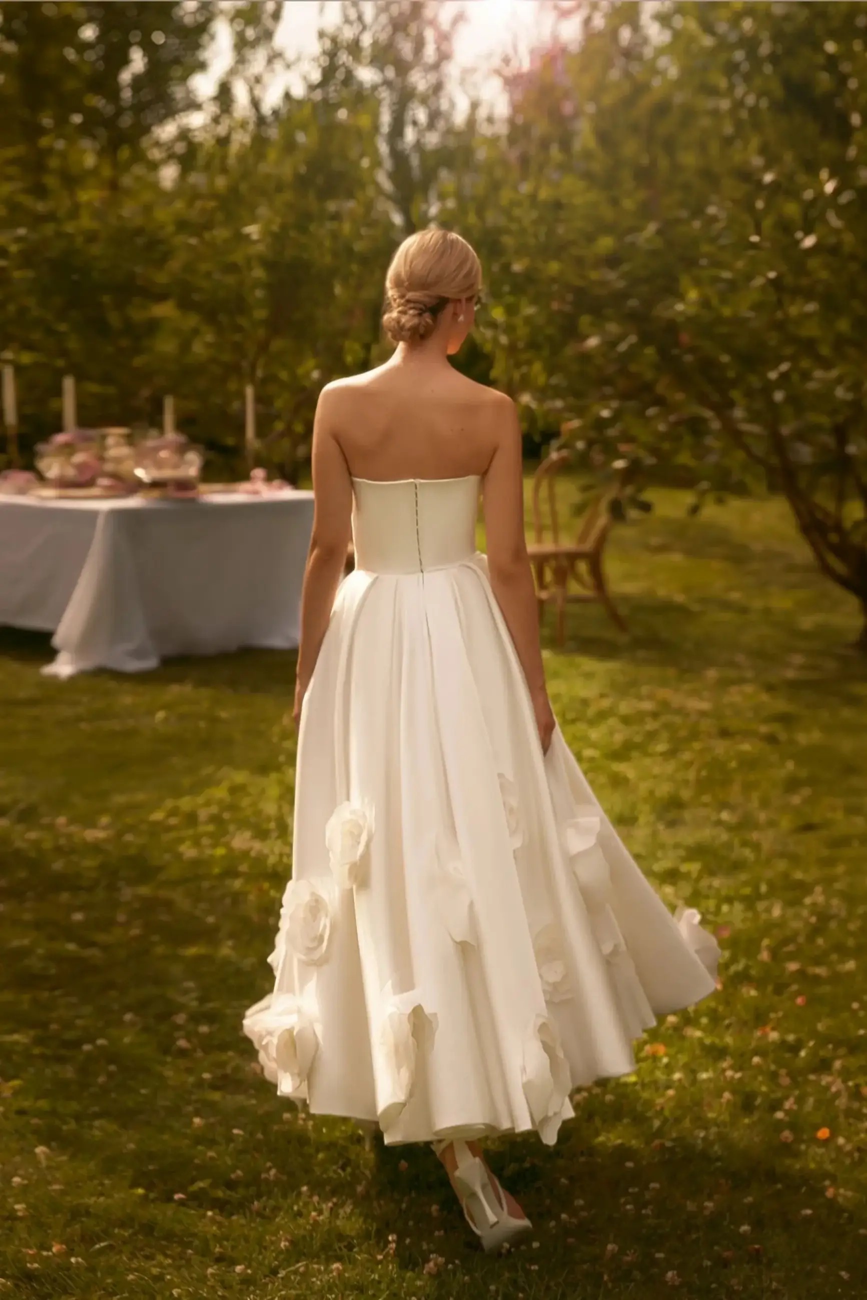 Model is wearing an a-line bridal gown with a puffy skirt and oversized 3d floral appliques