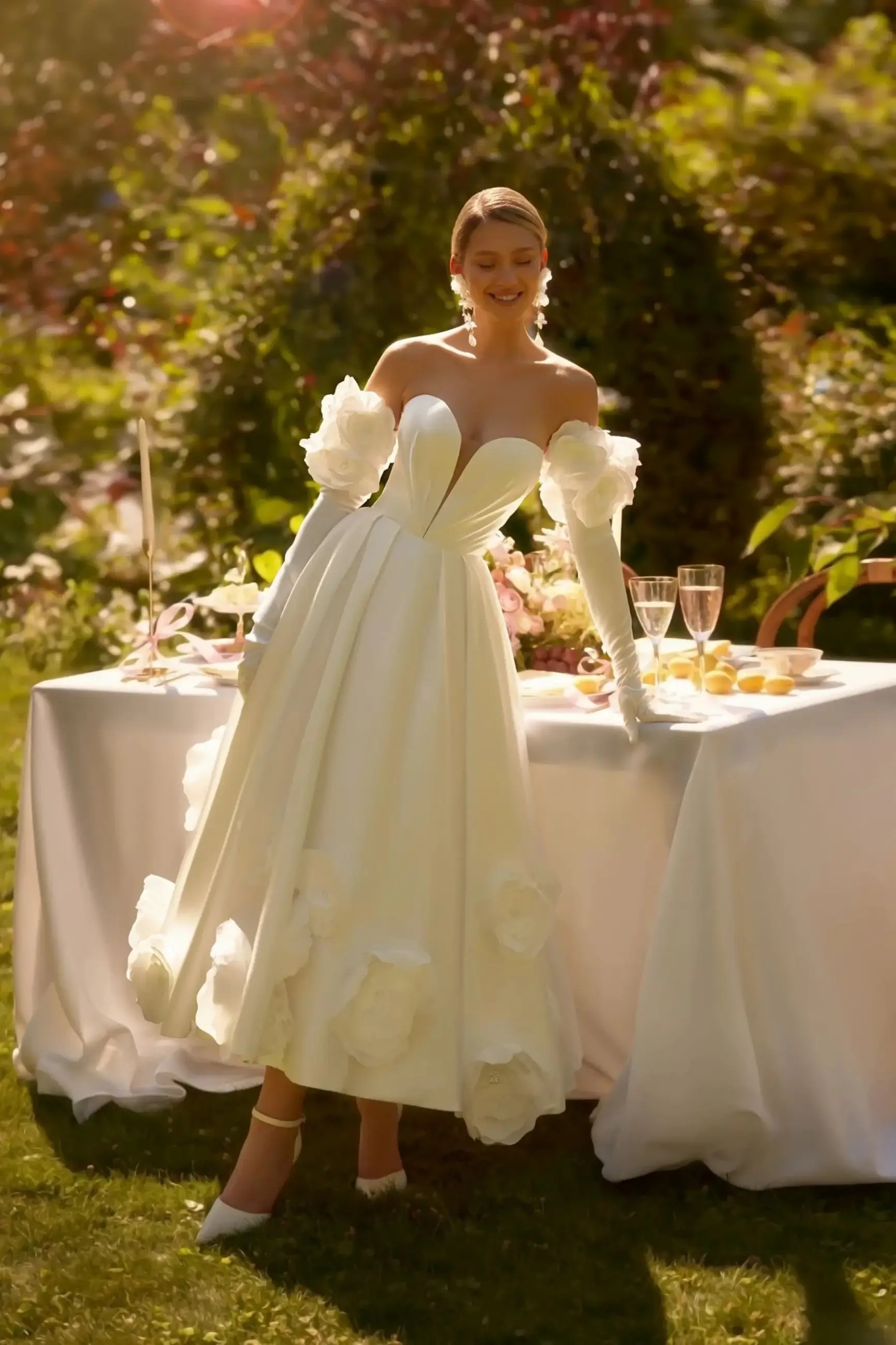 Model is wearing an a-line bridal gown with a puffy skirt and oversized 3d floral appliques