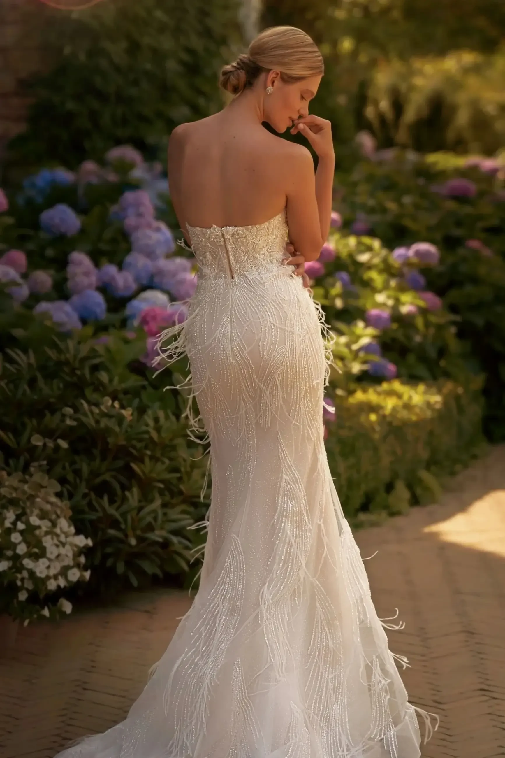 model is wearing a strapless fit and flare wedding dress with a detachable cape