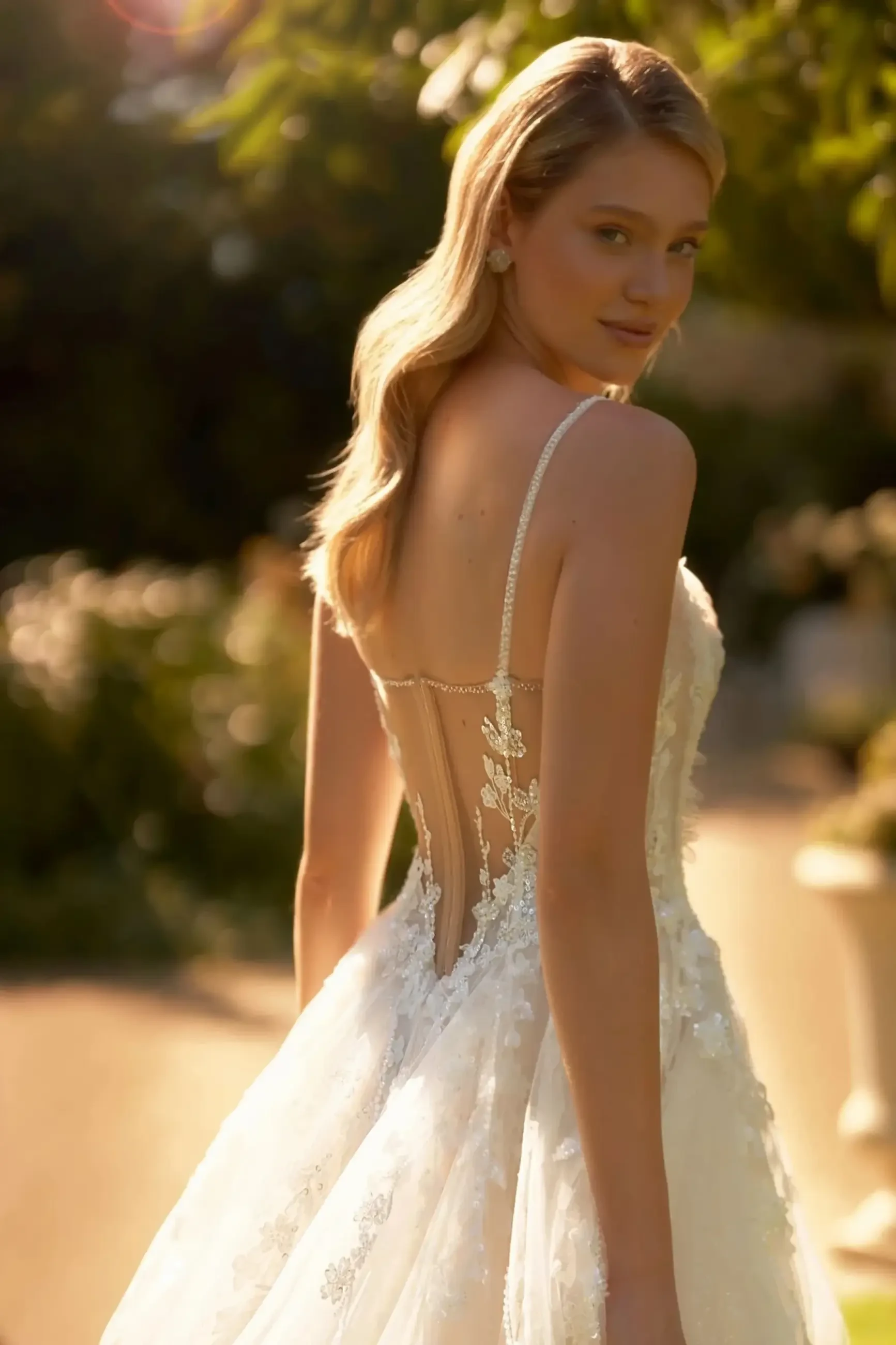 model is wearing an open back sleeveless wedding dress with detachable puff long sleeves