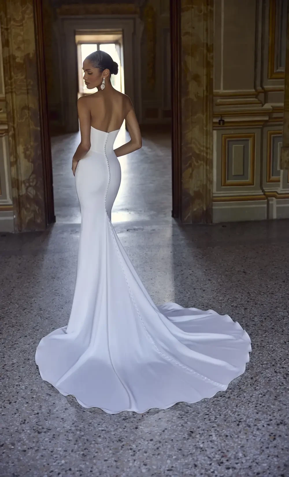 model is wearing a strapless open back bridal gown