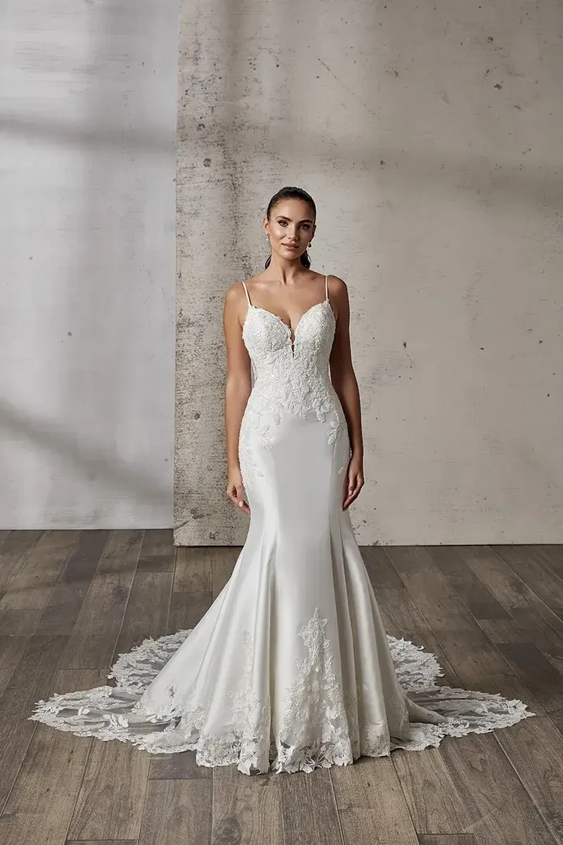 model is wearing an open back spaghetti strap wedding gown